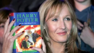 J.K. Rowling posando junto al libro 'Harry Potter y la piedra filosofal', el título que hizo arrancar una saga inolvidable.