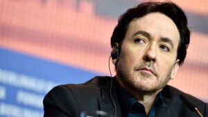 John Cusack atendiendo a los medios con cara de pocos amigos.